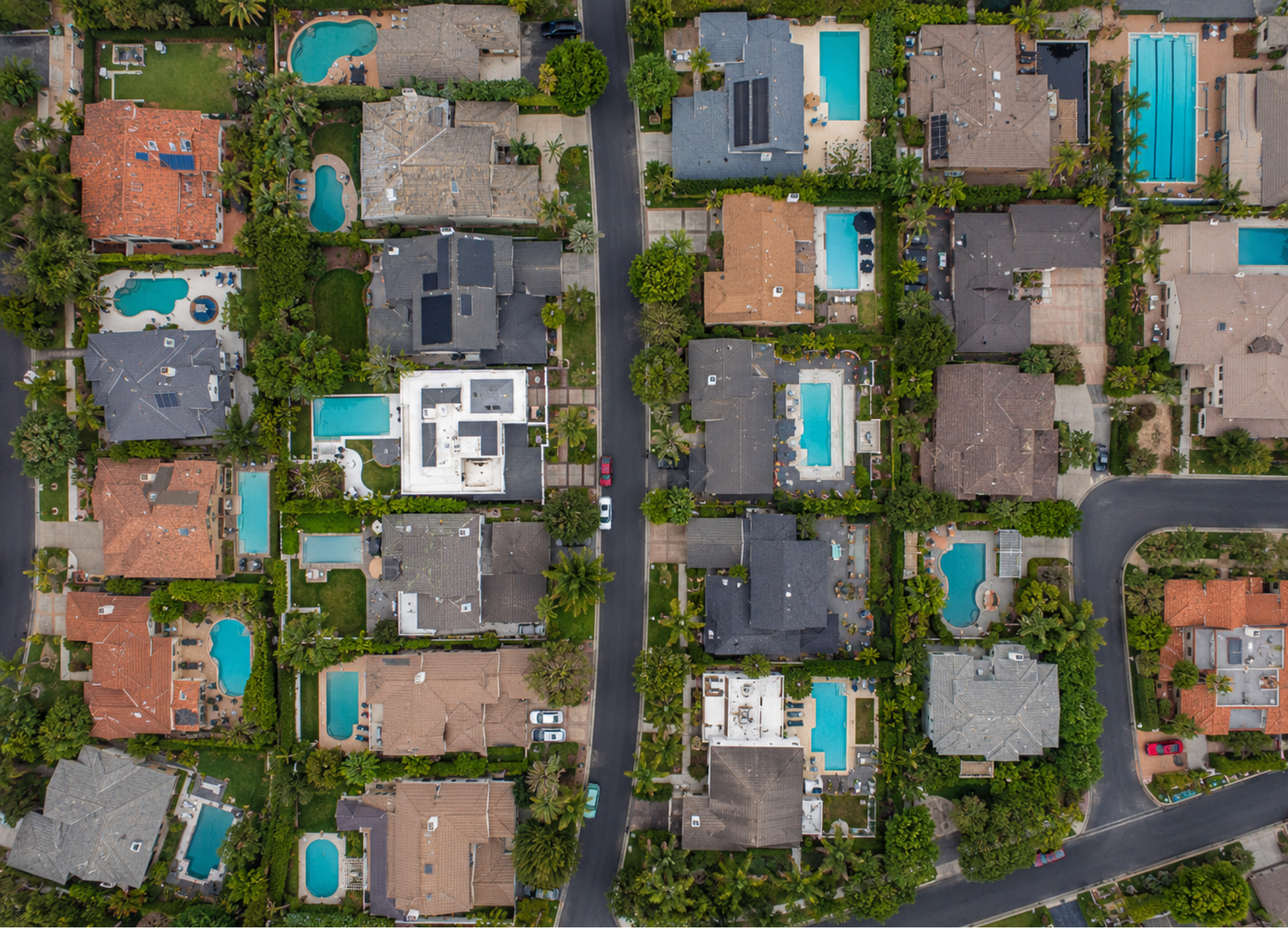 Aerial view of residential homes with backyard pools